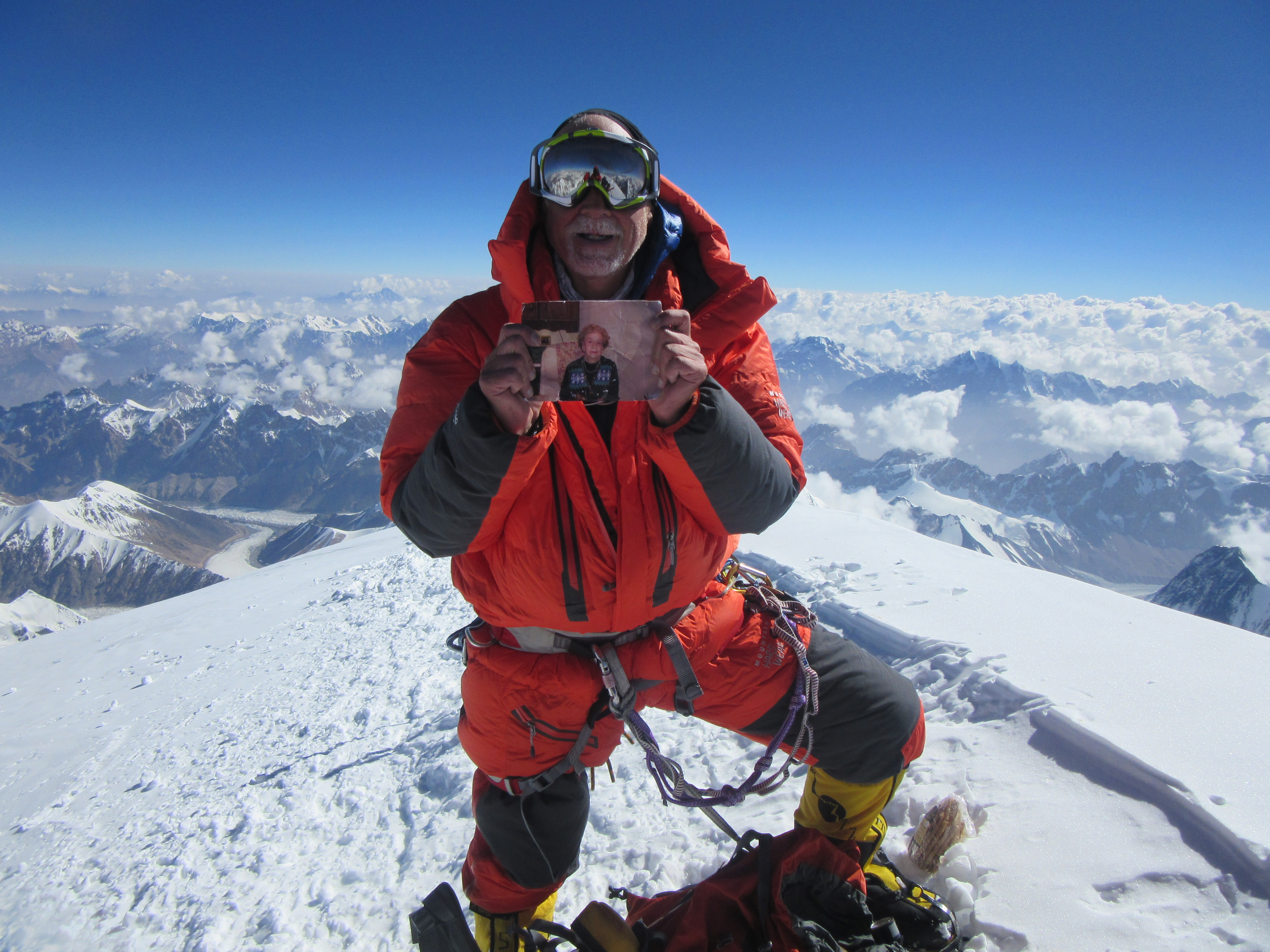 Alan Arnette on the summit of K2 holding a photograph of his mother Ida